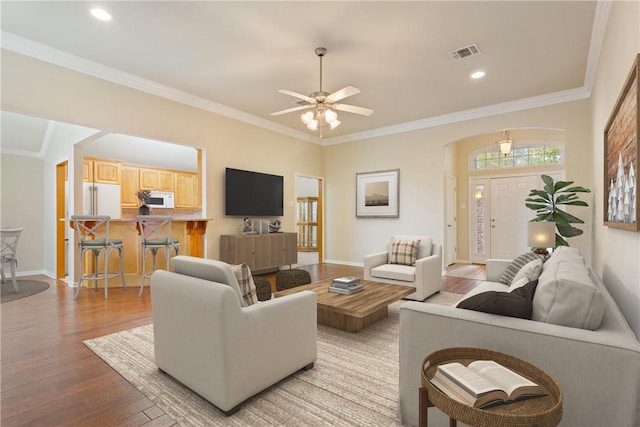 living room featuring ceiling fan, light hardwood / wood-style floors, and crown molding