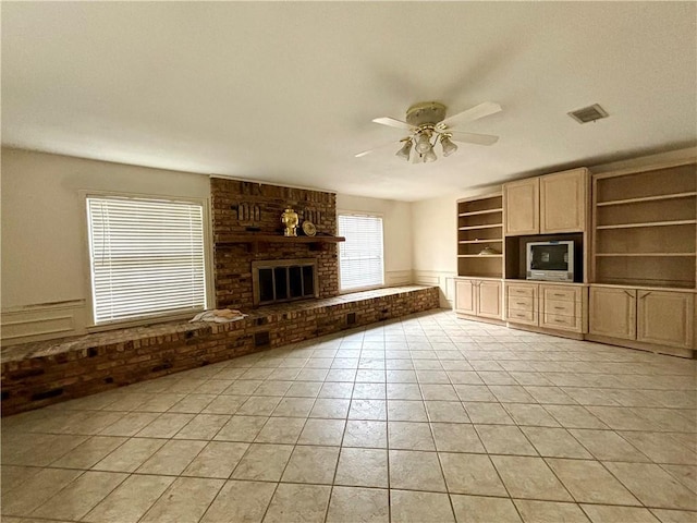 unfurnished living room featuring a brick fireplace, ceiling fan, and light tile patterned floors