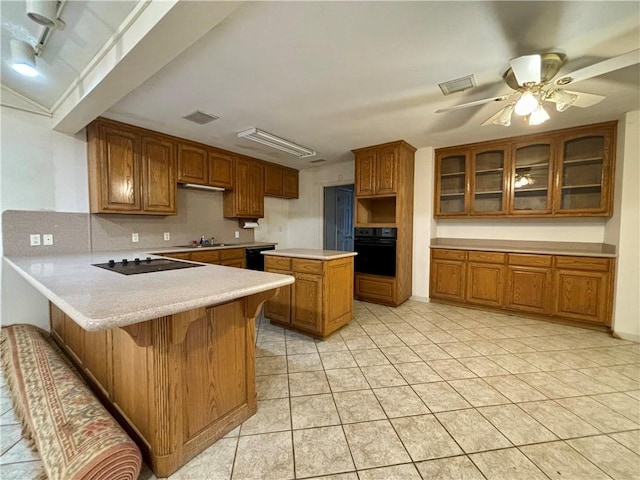 kitchen with black appliances, kitchen peninsula, ceiling fan, a kitchen bar, and decorative backsplash