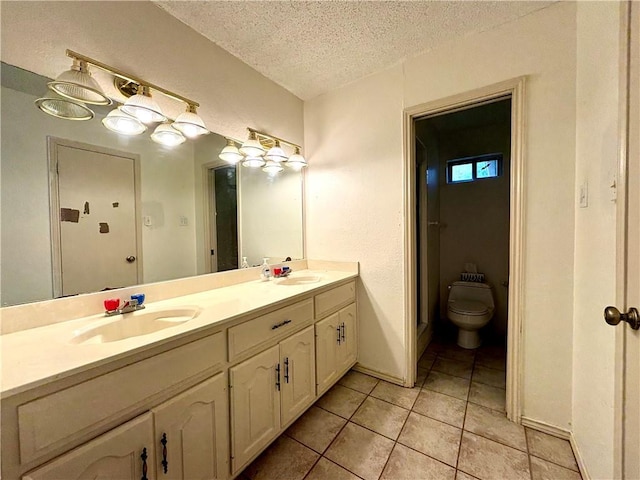 bathroom with toilet, a textured ceiling, tile patterned floors, and vanity