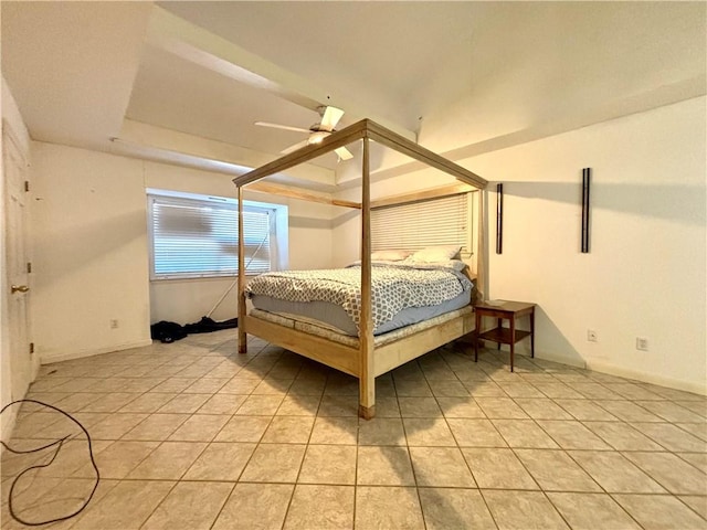 tiled bedroom with ceiling fan and a tray ceiling