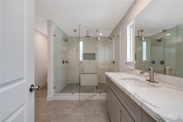 bathroom featuring tile patterned floors, vanity, a healthy amount of sunlight, and walk in shower