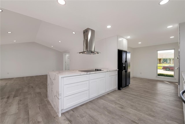 kitchen featuring white cabinetry, wall chimney exhaust hood, black appliances, and vaulted ceiling