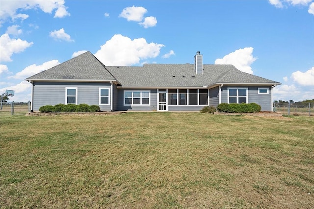 back of house with a sunroom and a lawn