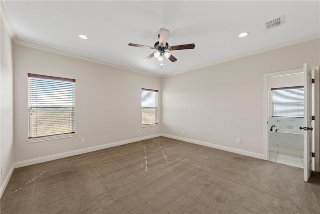 carpeted spare room with ceiling fan, plenty of natural light, and crown molding