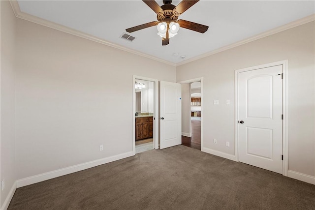 unfurnished bedroom with ceiling fan, ensuite bathroom, ornamental molding, and dark colored carpet