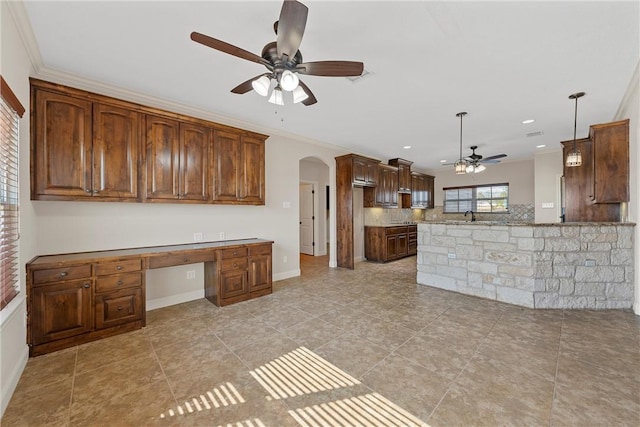 kitchen featuring ceiling fan, crown molding, kitchen peninsula, and decorative light fixtures