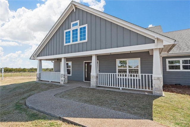 craftsman-style house featuring covered porch and a front lawn