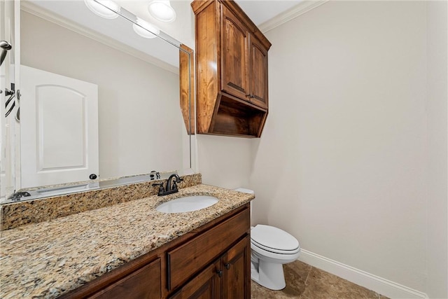 bathroom with toilet, vanity, and ornamental molding