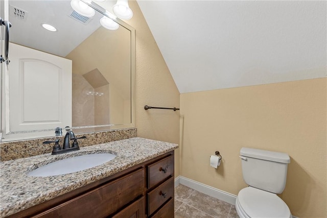 bathroom featuring tile patterned floors, toilet, vanity, and lofted ceiling