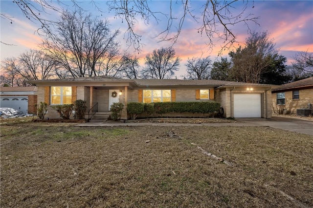 ranch-style house with a garage, central AC, a front lawn, and concrete driveway