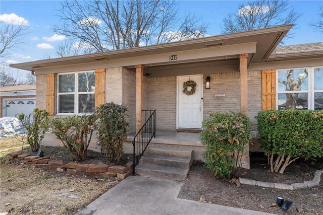 property entrance featuring a porch and brick siding