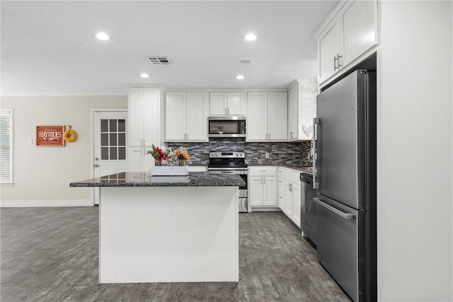 kitchen featuring stainless steel appliances, tasteful backsplash, visible vents, white cabinetry, and a kitchen island