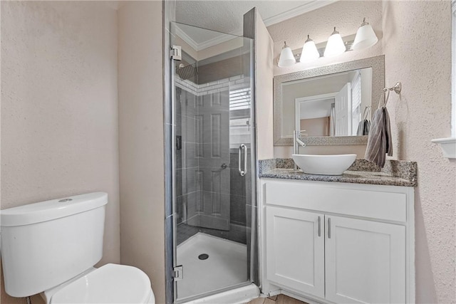 full bathroom with toilet, a textured wall, a stall shower, and vanity