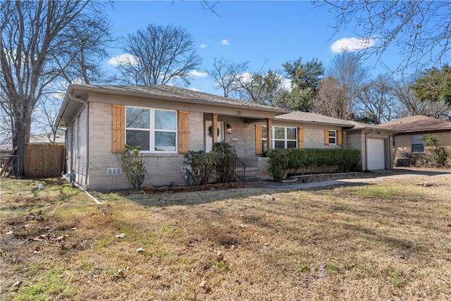 ranch-style house featuring a front lawn, brick siding, fence, and an attached garage