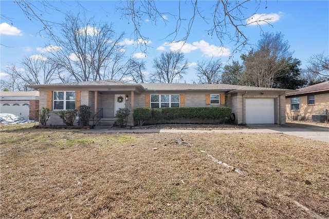 ranch-style house with cooling unit, a garage, brick siding, driveway, and a front yard