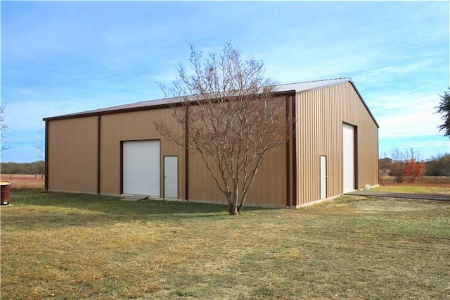 view of outdoor structure with a garage and a lawn