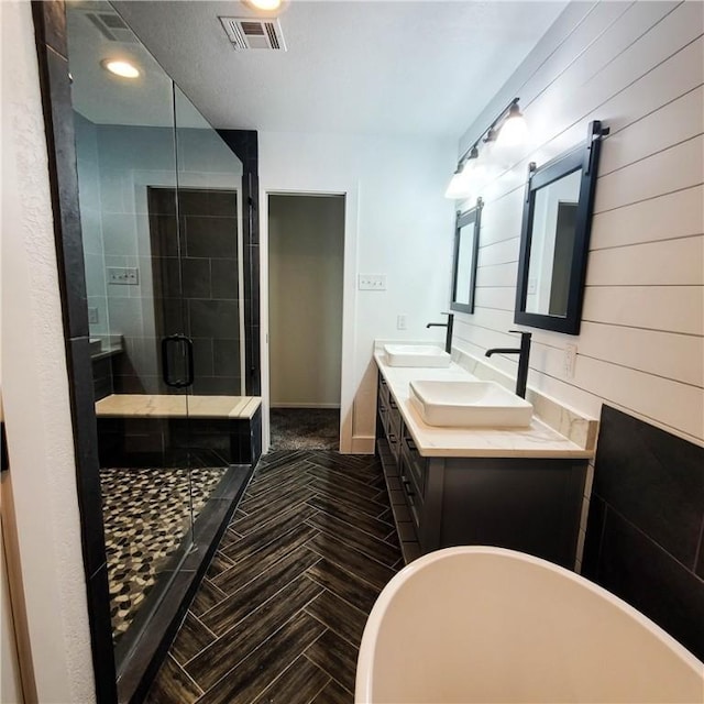 bathroom featuring vanity, wooden walls, and plus walk in shower