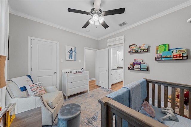 bedroom featuring connected bathroom, visible vents, wood finished floors, and ornamental molding