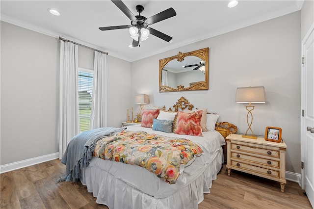 bedroom with baseboards, crown molding, and wood finished floors