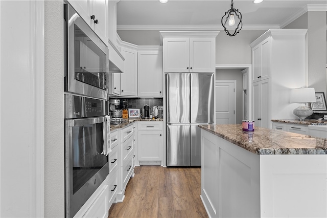 kitchen with light wood-style floors, decorative backsplash, stainless steel appliances, and crown molding