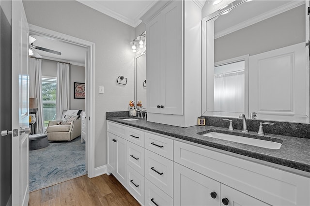 bathroom featuring wood finished floors, a sink, a ceiling fan, and crown molding