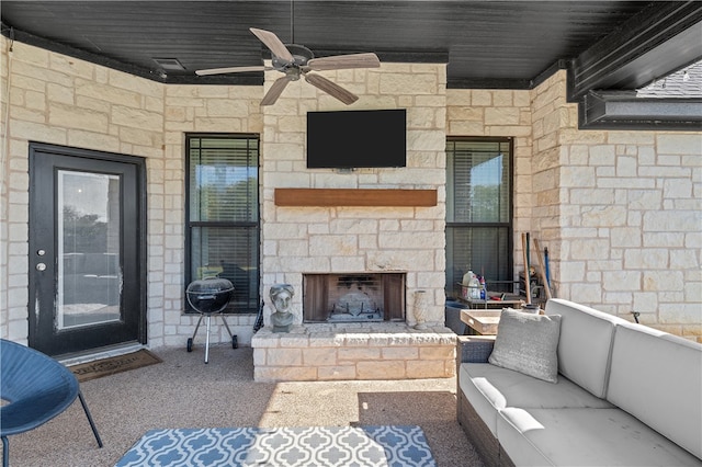 view of patio with an outdoor living space with a fireplace and a ceiling fan