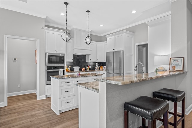 kitchen with light stone counters, appliances with stainless steel finishes, a breakfast bar, a peninsula, and crown molding