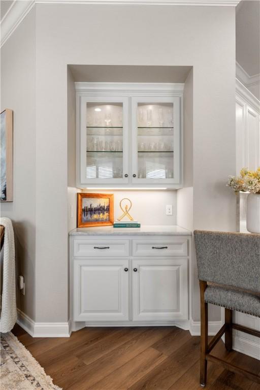 bar with white cabinetry and dark hardwood / wood-style flooring