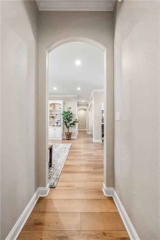 hallway with hardwood / wood-style flooring and crown molding