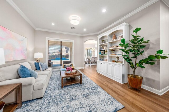 living room featuring light hardwood / wood-style floors and crown molding