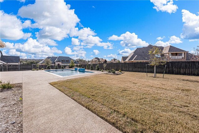 view of yard featuring pool water feature, a patio, and a fenced in pool