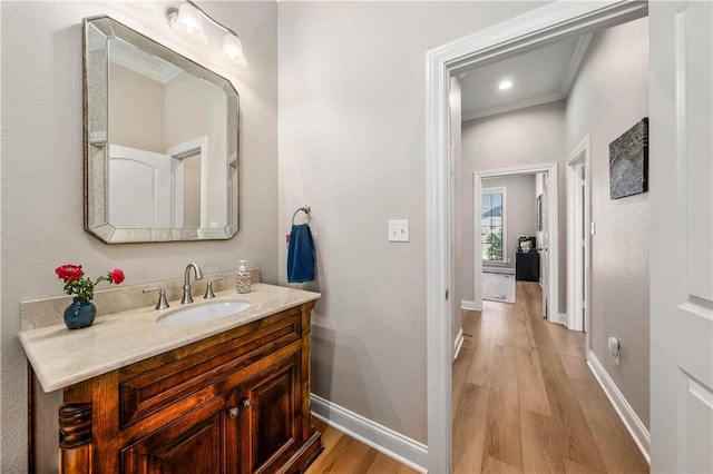 bathroom with vanity, ornamental molding, and hardwood / wood-style floors