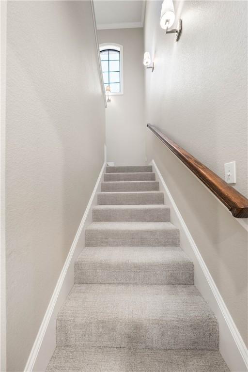 staircase featuring ornamental molding