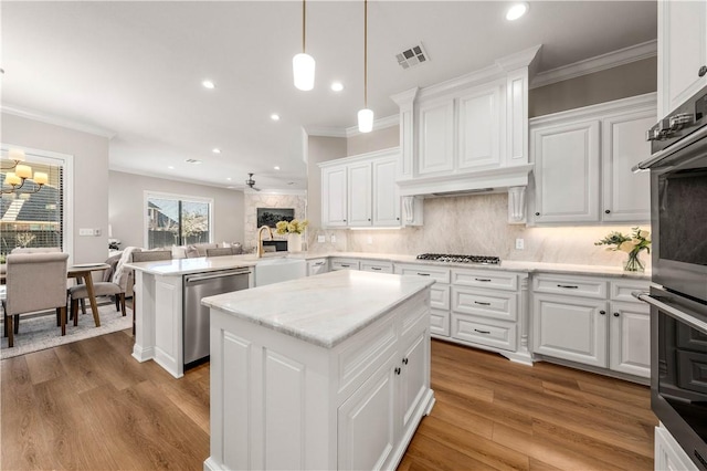 kitchen featuring appliances with stainless steel finishes, white cabinets, kitchen peninsula, and tasteful backsplash