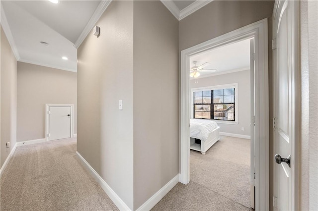 hall with ornamental molding and light colored carpet