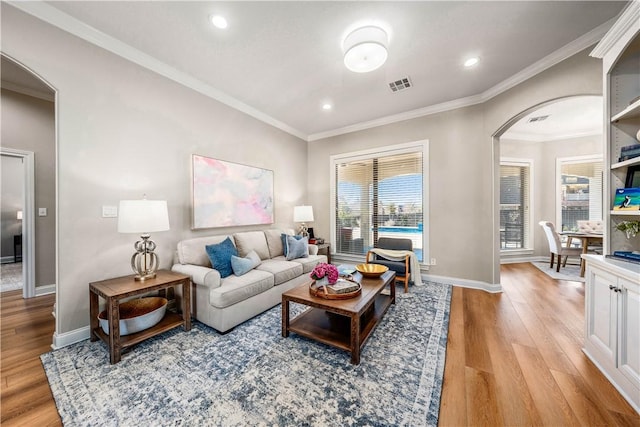 living room with light wood-type flooring and ornamental molding