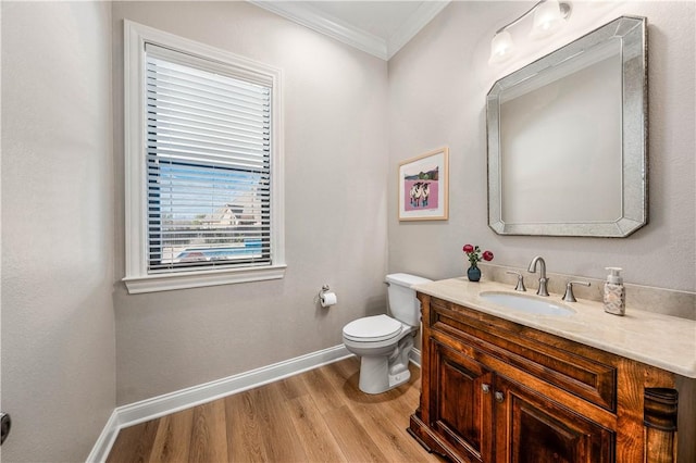 bathroom featuring wood-type flooring, toilet, vanity, and ornamental molding