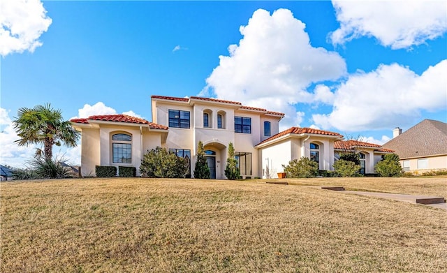 mediterranean / spanish home featuring a front lawn