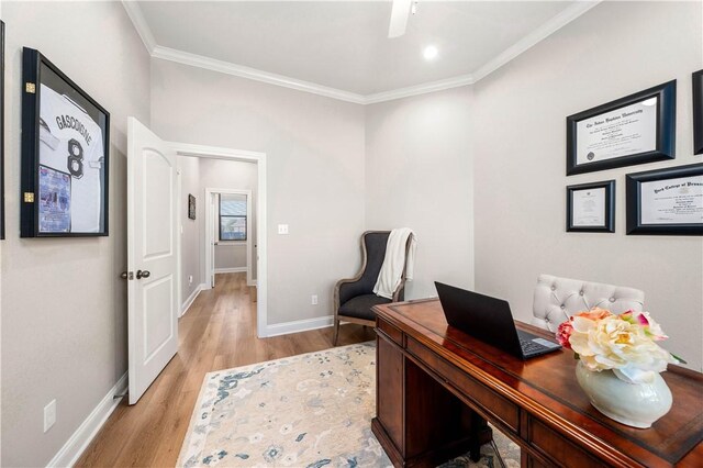 home office with light hardwood / wood-style flooring and ornamental molding