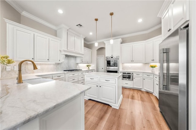 kitchen featuring stainless steel appliances, white cabinetry, tasteful backsplash, and sink