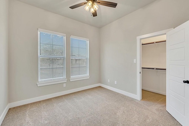 unfurnished bedroom with ceiling fan, light colored carpet, and a closet