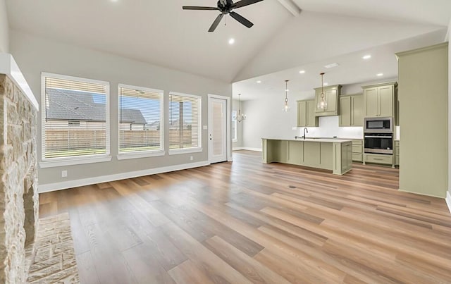 unfurnished living room featuring light wood-type flooring, ceiling fan, sink, high vaulted ceiling, and beamed ceiling