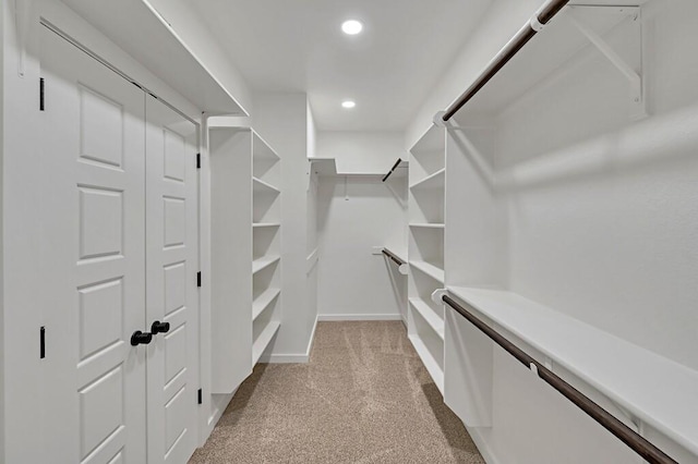 walk in closet featuring light carpet