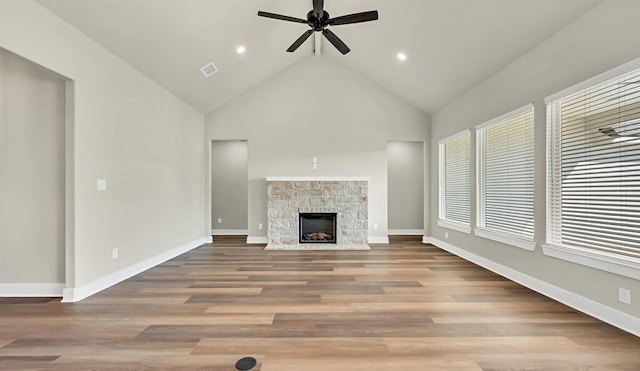 unfurnished living room with ceiling fan, a fireplace, high vaulted ceiling, and light hardwood / wood-style floors