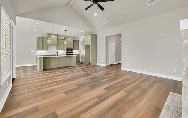 unfurnished living room featuring beamed ceiling, light hardwood / wood-style floors, high vaulted ceiling, and ceiling fan