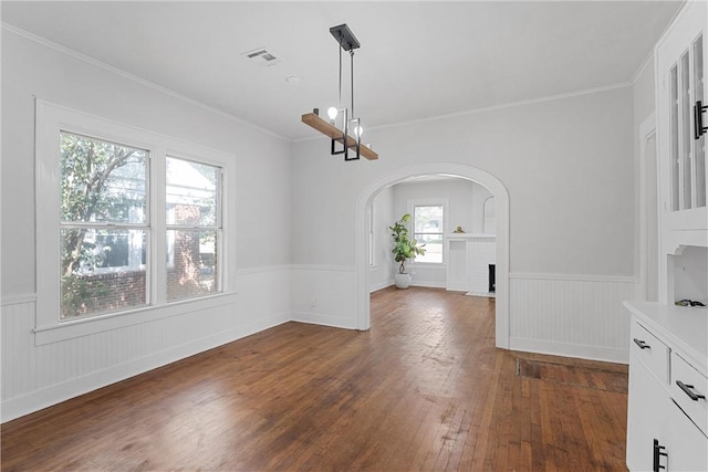 unfurnished dining area with dark hardwood / wood-style flooring, a brick fireplace, and crown molding