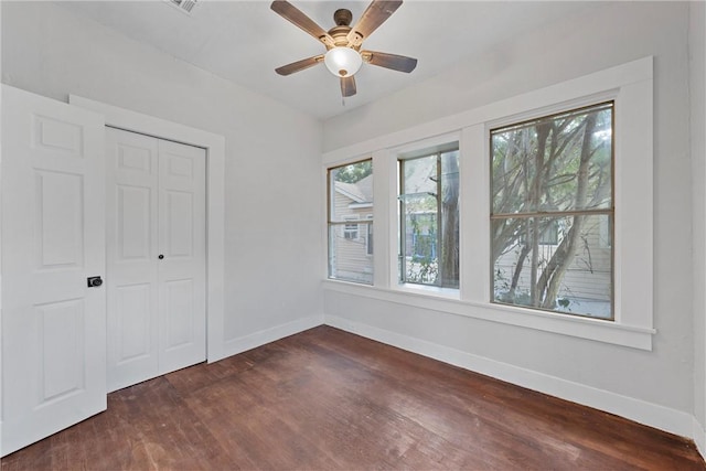 unfurnished bedroom featuring dark hardwood / wood-style flooring, a closet, and ceiling fan