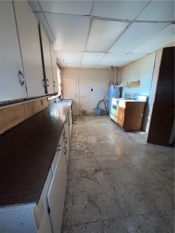 kitchen with white cabinets, electric water heater, and a drop ceiling