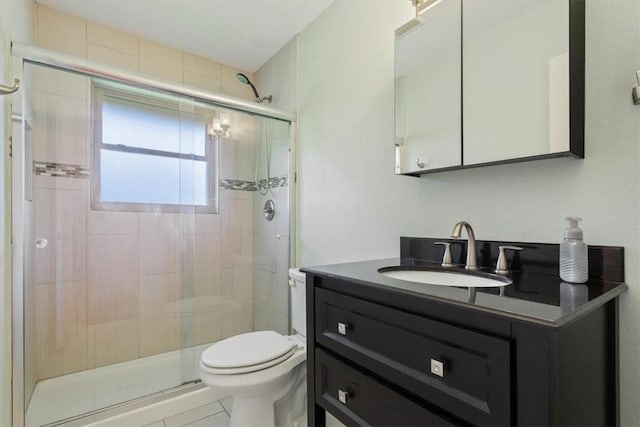 bathroom featuring tile patterned flooring, vanity, a shower with door, and toilet